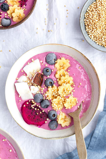 From above of power bowl full of tasty smoothie near ripe banana and dragon fruit slices with blueberries for breakfast — Stock Photo