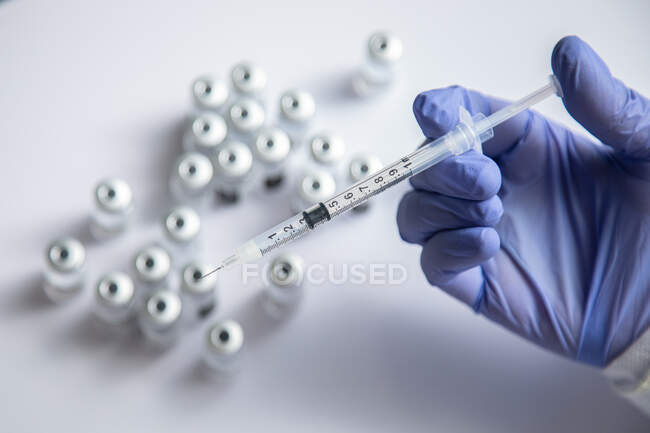 Анонімний жіночий лікар з пляшкою вакцини та шприцом. — стокове фото