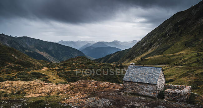 Grand angle de petit bâtiment en brique sur un terrain herbeux dans les magnifiques montagnes des Pyrénées sous un ciel couvert en Catalogne — Photo de stock