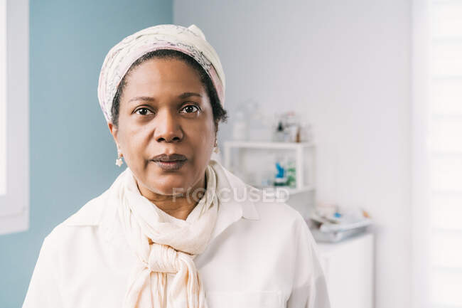 Afroamericana madura paciente en clínica esperando cita durante cita - foto de stock