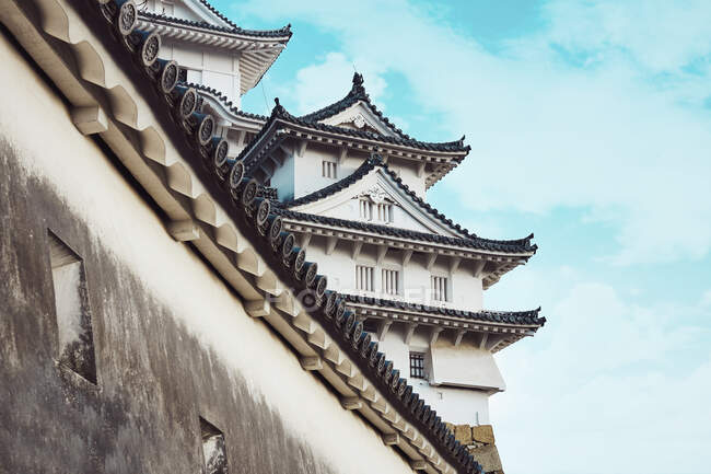 De baixo do tradicional Castelo Himeji com telhados curvos no fundo do céu azul no Japão — Fotografia de Stock