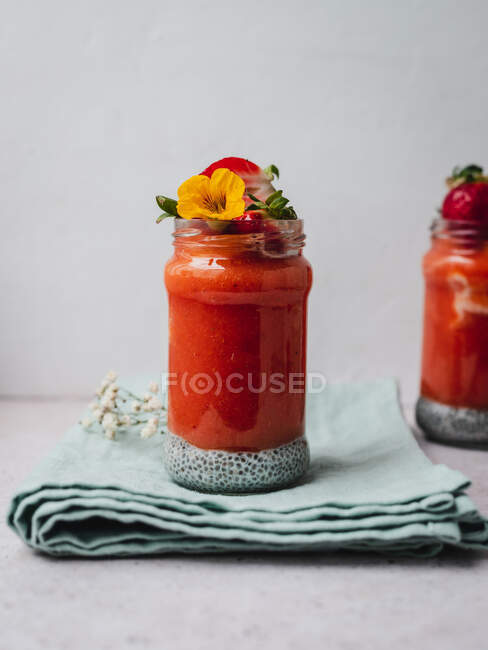 Closeup of a delicious strawberry smoothie with a yellow flower garnish — Stock Photo
