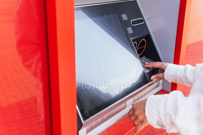 Нерозбірлива жінка використовує термінал банкомата і витягує готівку стоячи на вулицях міста. — стокове фото