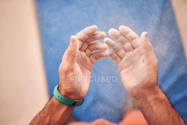 From above of crop unrecognizable male climber with hands in talcum standing in modern bouldering club — Stock Photo