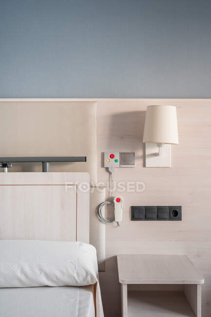 Sistema di chiamata infermiere con pulsanti di emergenza installati vicino al letto in ambienti medici interni minimalisti in ospedale — Foto stock