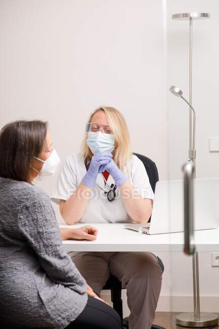Doctora atendiendo a una paciente en su consultorio médico - foto de stock