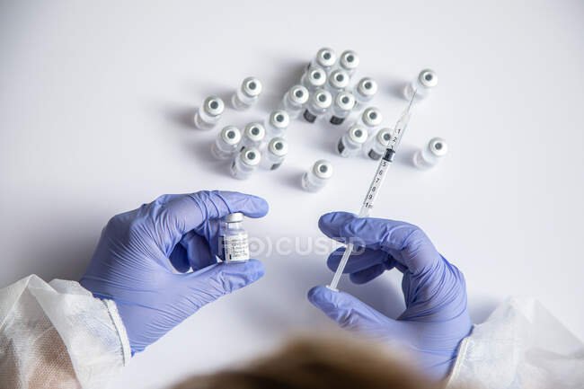 Анонимная женщина-врач с бутылкой вакцины и шприцем — стоковое фото