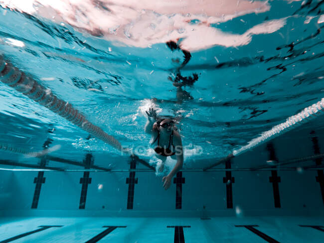 Frau krabbelt in Pool und bereitet sich auf Wettkampf vor — Stockfoto
