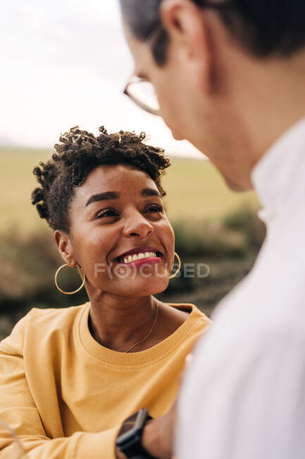 High angle of happy black woman looking at man with love while standing in nature — Stock Photo