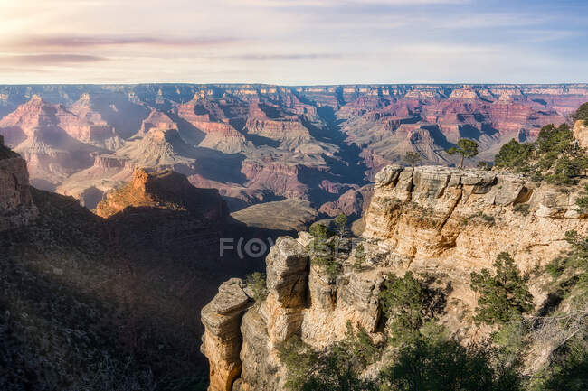 De cima da paisagem pitoresca de formações rochosas ásperas e rio colocado no Grand Canyon National Park, no Arizona, nos Estados Unidos, sob o céu colorido do topo da montanha — Fotografia de Stock
