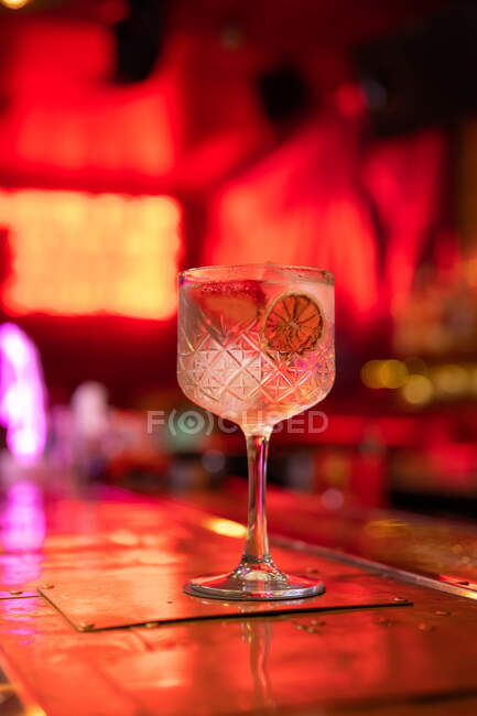 Well elaborated gin tonic cocktail decorated with strawberries and slide of dry lemon in the bar — Stock Photo