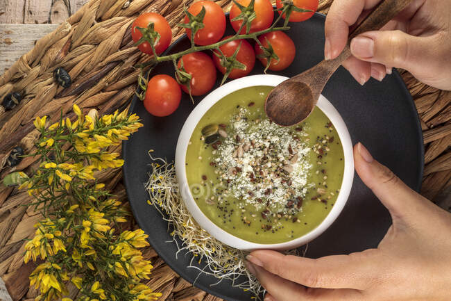 Vista aerea di coltura anonimo chef con ciotola di gustosa zuppa di crema vegetariana con pistacchi schiacciati e condimenti in cima — Foto stock