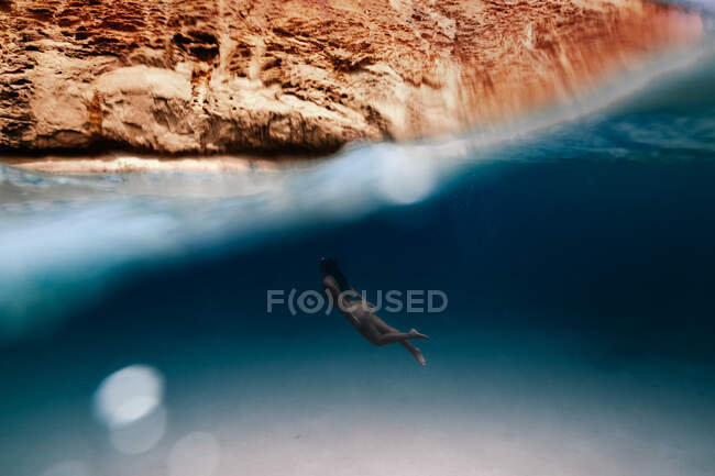 Touristin im Badeanzug schwimmt im sauberen, transparenten Meer während ihres Urlaubs im sonnigen tropischen Badeort — Stockfoto
