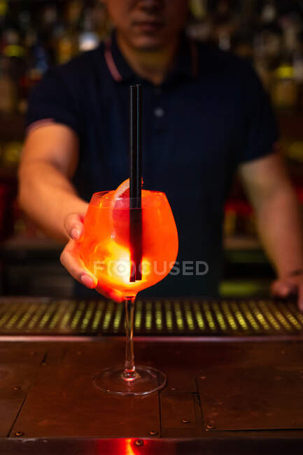 Joven camarero asiático le da un zumo de pomelo gin cocktail en el bar después de que terminó de prepararlo - foto de stock