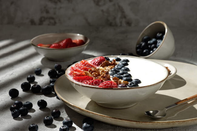 Vista dall'alto di deliziosa ciotola per la colazione sana con yogurt bianco e fragole fresche e mirtilli con muesli — Foto stock