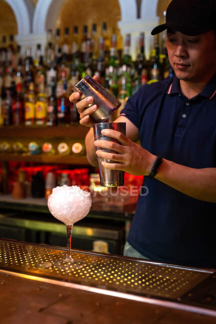 Бармен працює з шейкером для змішування коктейлю в барі. — стокове фото