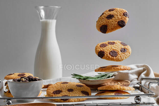 Deliciosos biscoitos doces caseiros com navios de chocolate servidos na bandeja com jarra de vidro de leite — Fotografia de Stock