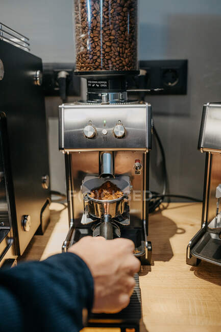 Cultivar barista irreconhecível usando moedor de café enquanto prepara café fresco aromático no café durante o dia — Fotografia de Stock