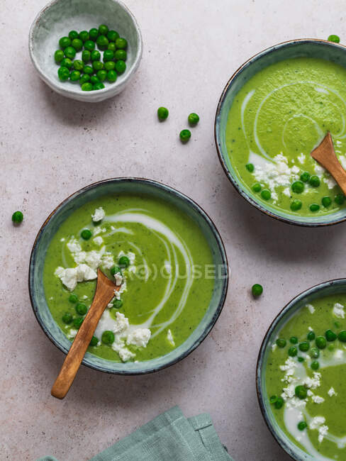 Top view of delicious pea cream soup in bowls served on table with napkin — Stock Photo