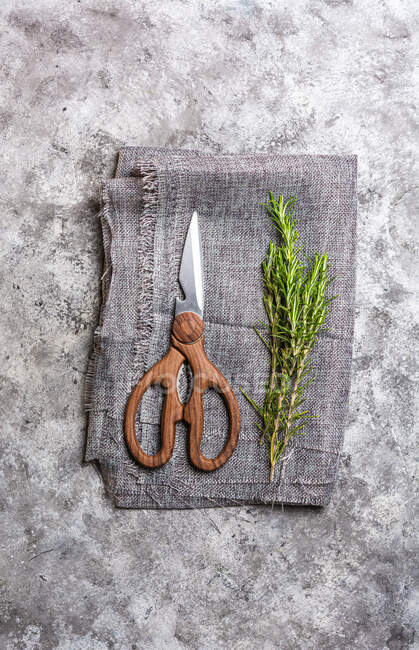 Top view of rosemary sprigs with green leaves near scissors on textile on table — Stock Photo