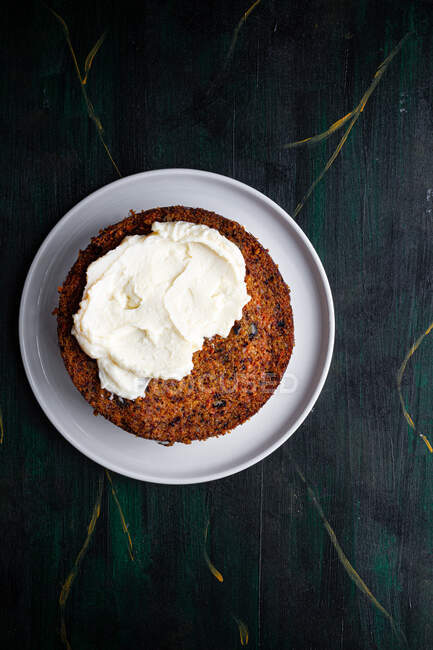 Vue aérienne du délicieux biscuit au gâteau mou sur assiette avec crème tartinée sur table — Photo de stock