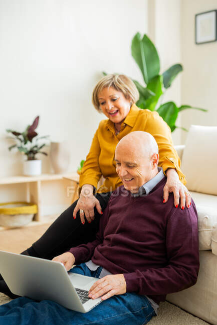 Alegre maduro casal falando no vídeo chat no laptop na sala de estar — Fotografia de Stock