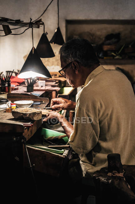 Сторона зору зрілого етнічного чоловіка, який працює на проводці в майстерні з виготовлення меблів. — стокове фото