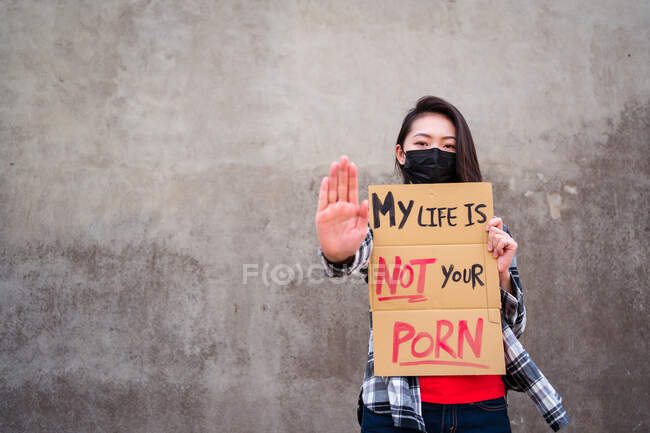 Donna etnica in maschera protettiva in piedi con My Life Is Not Your Porn cartello di cartone durante la protezione contro le molestie sessuali e aggressione — Foto stock