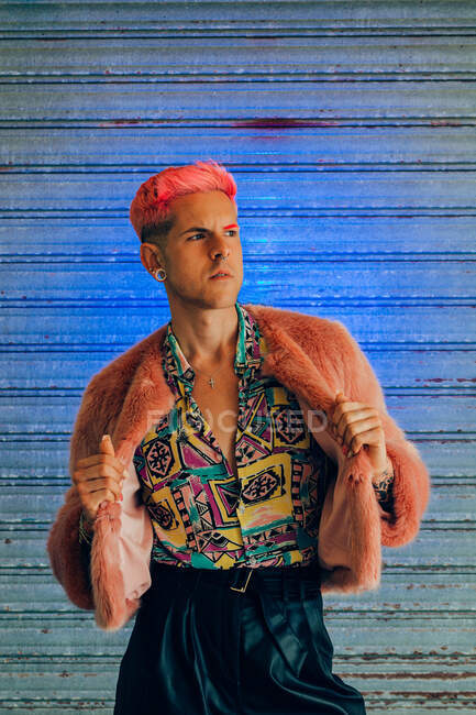 Jovem homossexual homem na moda desgaste com manicure e corte de cabelo moderno olhando para o fundo azul — Fotografia de Stock