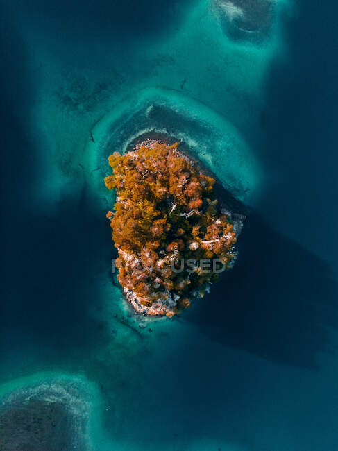 Зверху захоплюючий повітряний вид на острів у спокійному озері з бірюзовою водою, розташованою у високогір'ї — стокове фото