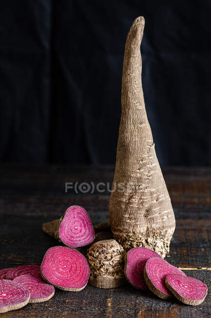 Composition of organic natural beetroot cut into slices and arranged on shabby wooden surface — Stock Photo