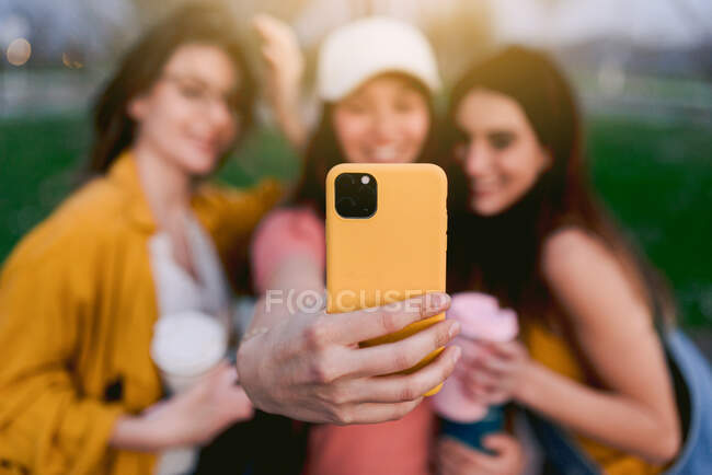 Alegres melhores amigos do sexo feminino tomando auto-retrato no celular enquanto passam o tempo juntos na cidade — Fotografia de Stock