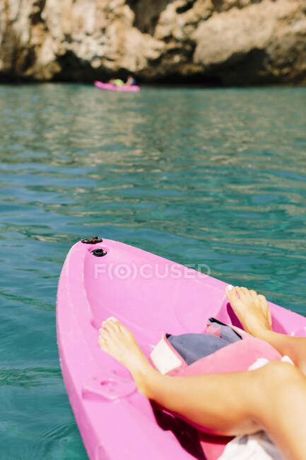 Side view of anonymous traveler with paddles floating on turquoise seawater near the rocky shore on sunny day in Malaga Spain — Stock Photo