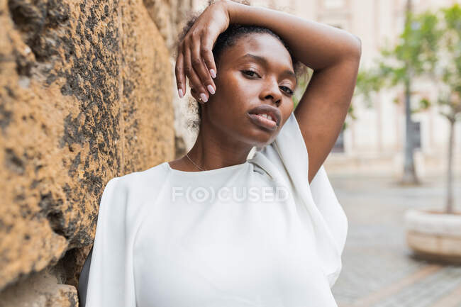 Portrait of attractive African American female standing in historic city district on warm spring day and looking away — Stock Photo
