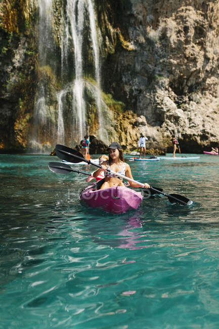 Viajantes com remos flutuando na água do mar turquesa perto da costa rochosa no dia ensolarado em Málaga Espanha — Fotografia de Stock