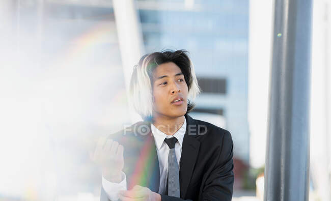 Joven ejecutivo masculino étnico bien vestido en camisa blanca con corbata y chaqueta sobre fondo borroso - foto de stock