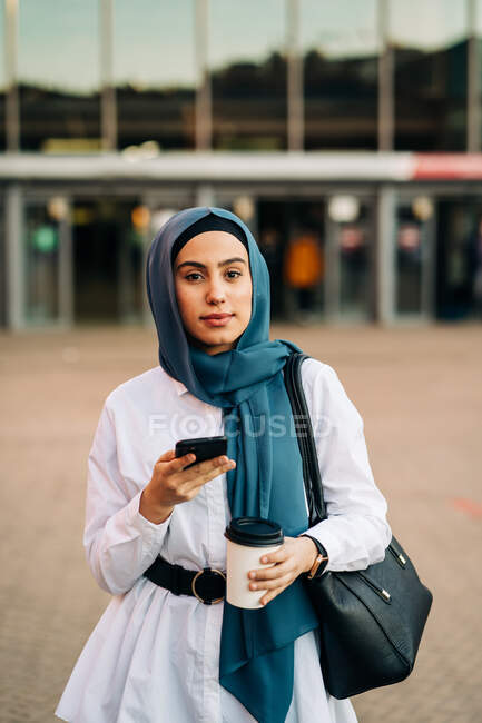 Donna musulmana smartphone di navigazione vicino alla stazione ferroviaria — Foto stock