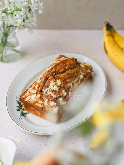 De cima de bolo delicioso com flocos de amêndoa doce na placa na mesa — Fotografia de Stock