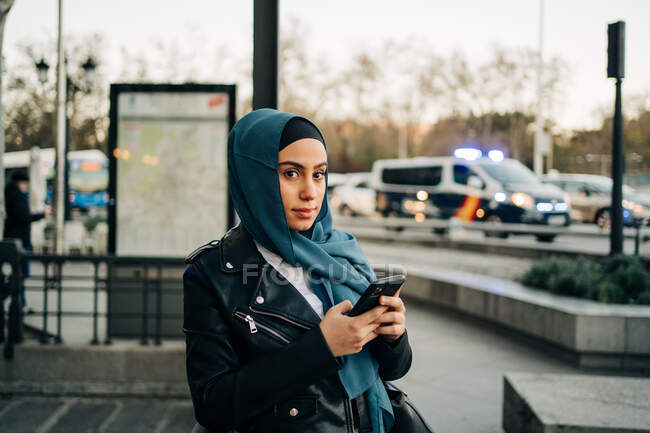 Charmante Muslimin mit Kopftuch steht auf der Straße und schaut in die Kamera — Stockfoto
