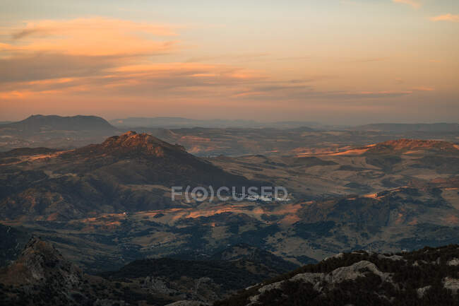 Vista panorâmica do terreno montanhoso espaçoso com encostas cobertas com vegetação sob o céu do pôr do sol em Sevilha Espanha — Fotografia de Stock