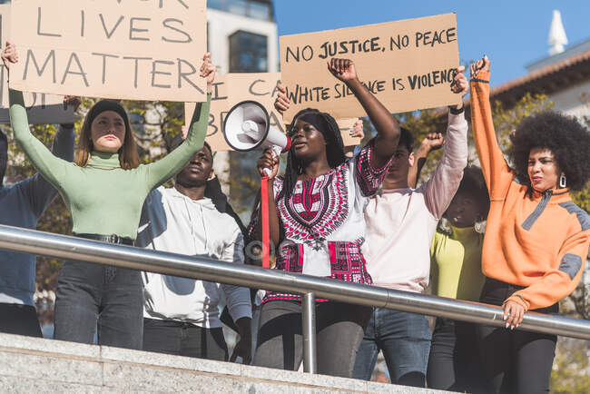 From below of crowd of multiracial protesters with placards and megaphone standing on street during Black Lives Matter protest — Fotografia de Stock