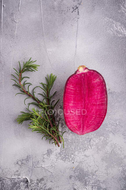 Vista dall'alto del tenero petalo di fiori rosa vicino a rametti di rosmarino aromatici su una superficie robusta con macchie — Foto stock