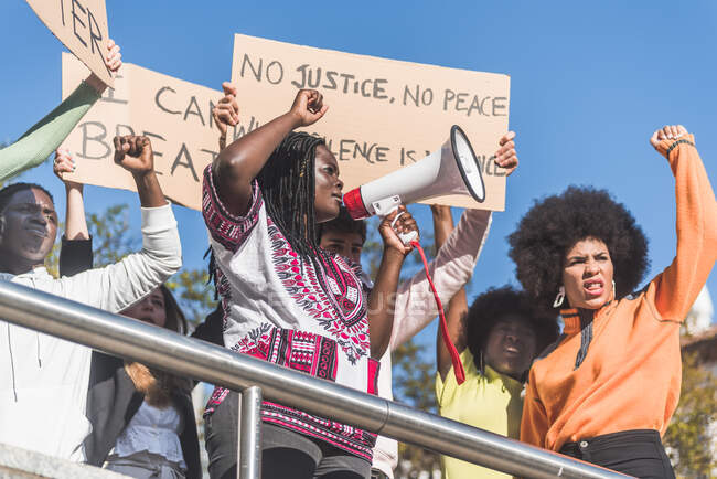 From below of crowd of multiracial protesters with placards and megaphone standing on street during Black Lives Matter protest — Fotografia de Stock