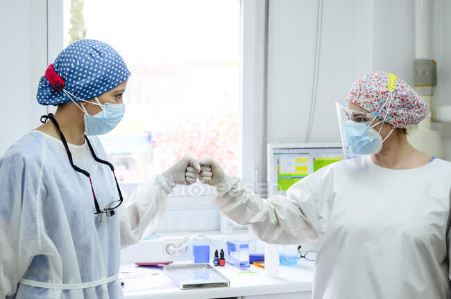 Médecins en uniforme se saluant avec cinq hauts au travail à l'hôpital — Photo de stock