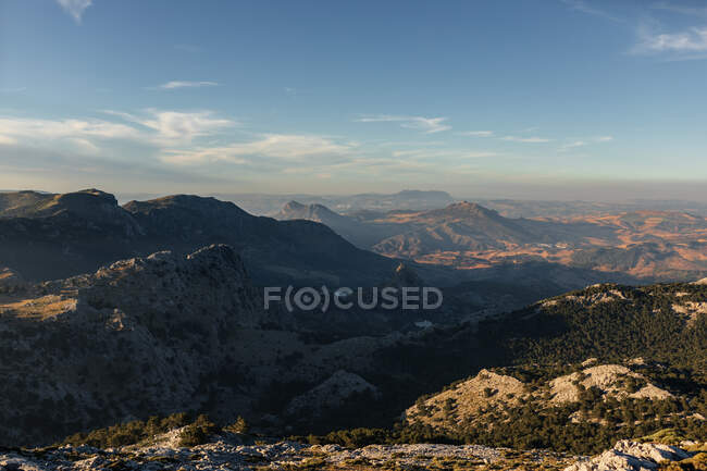 Vista panorámica del amplio terreno montañoso con laderas cubiertas de vegetación bajo el cielo azul sin nubes en Sevilla España - foto de stock
