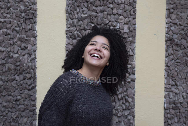 Delighted ethnic female with Afro hairstyle standing on street while look up — Stock Photo
