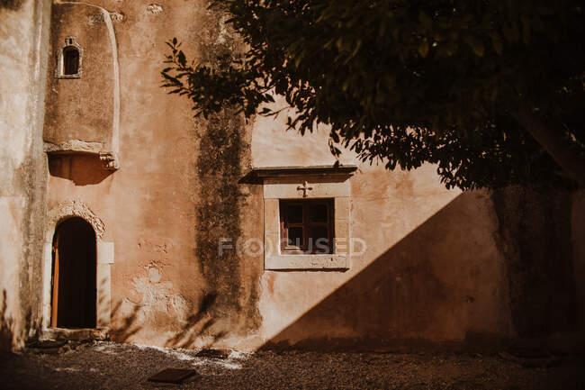 Экстерьер исторического монастыря Аркадий с арочной дверью и небольшими окнами, расположенными на Крите, Греция — стоковое фото