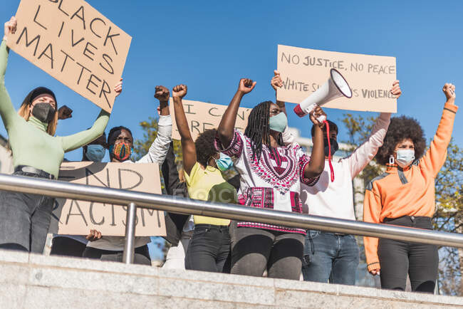 Von unten von der Menge der multirassischen Demonstranten mit Plakaten und Megafon, die während des Protests der Schwarzen auf der Straße stehen — Stockfoto