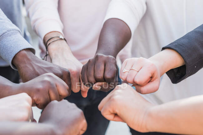 Группа обрезанных неузнаваемых многонациональных протестующих, стоящих с сжатым кулаком во время демонстрации черных жизней — стоковое фото