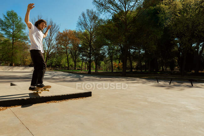 Uomo che cavalca skateboard in un parco — Foto stock